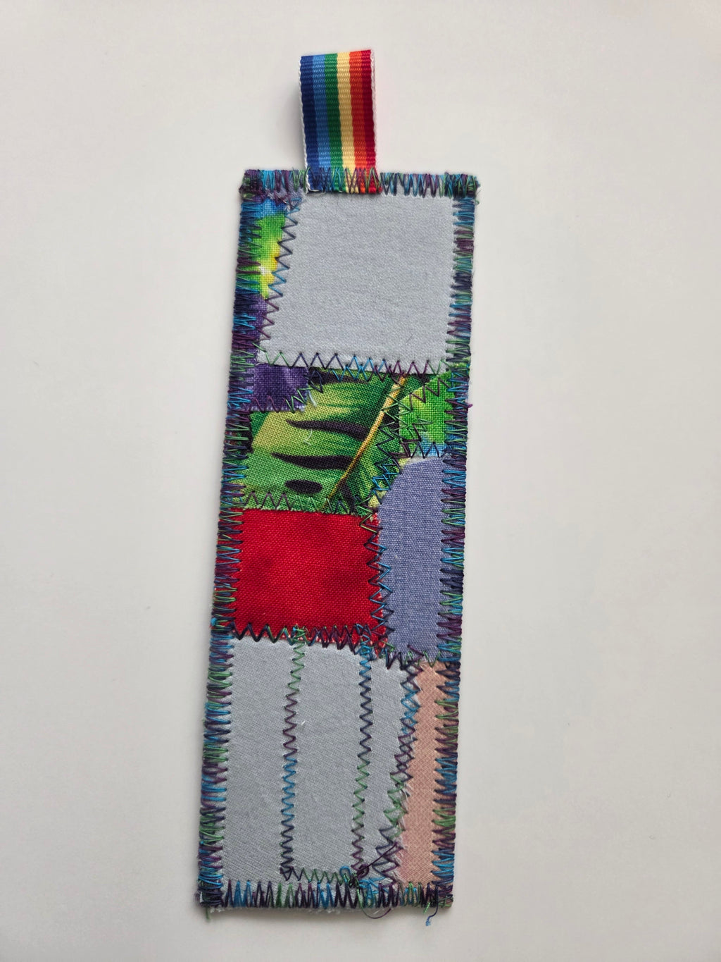 Colorful fabric bookmark with a leaf design on a light gray background