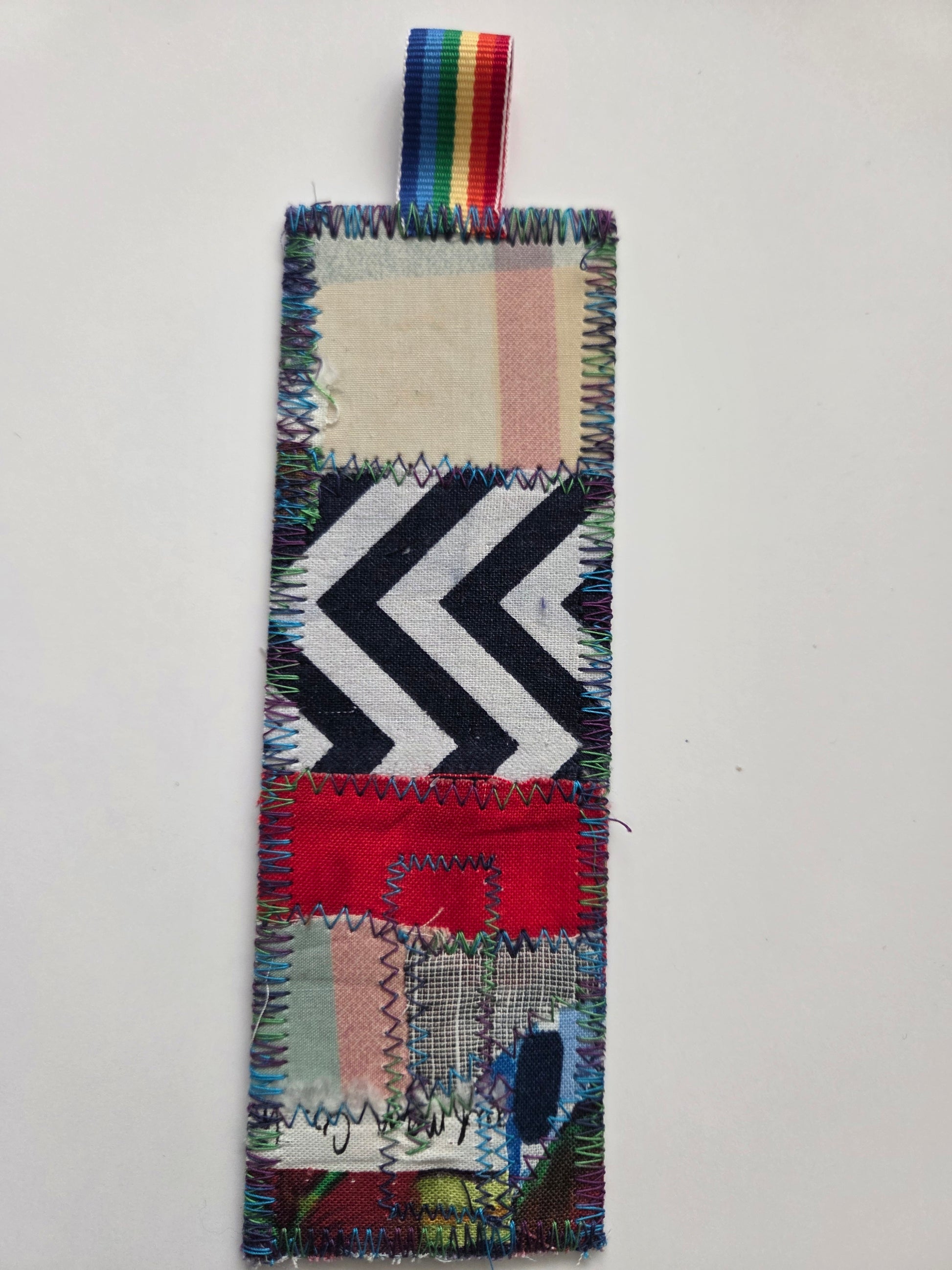 Colorful patchwork bookmark with a rainbow ribbon on a white background