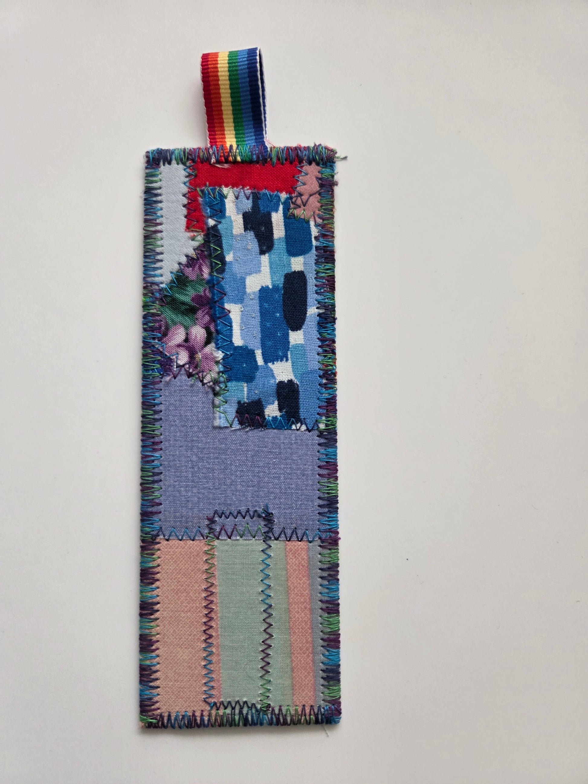 Colorful woven bookmark with a multicolored ribbon on a light gray background