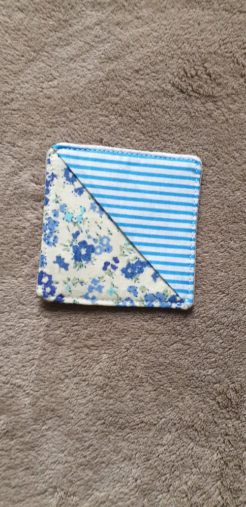 Folded fabric square with blue floral pattern on a brown surface